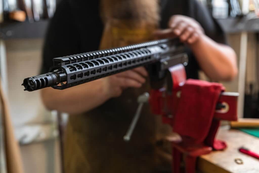 A gunsmith repairing a rifle closeup