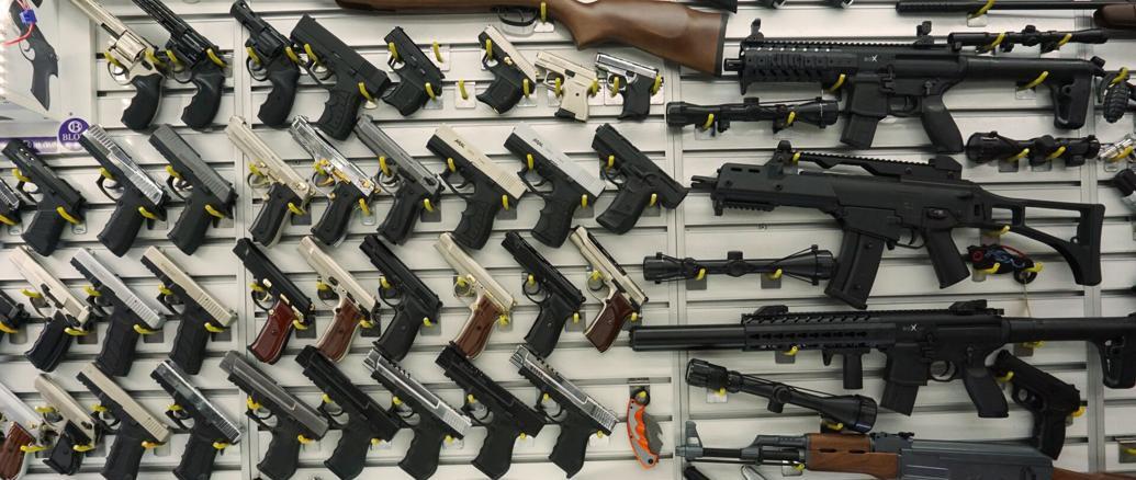 A selection of various firearms displayed on a wall