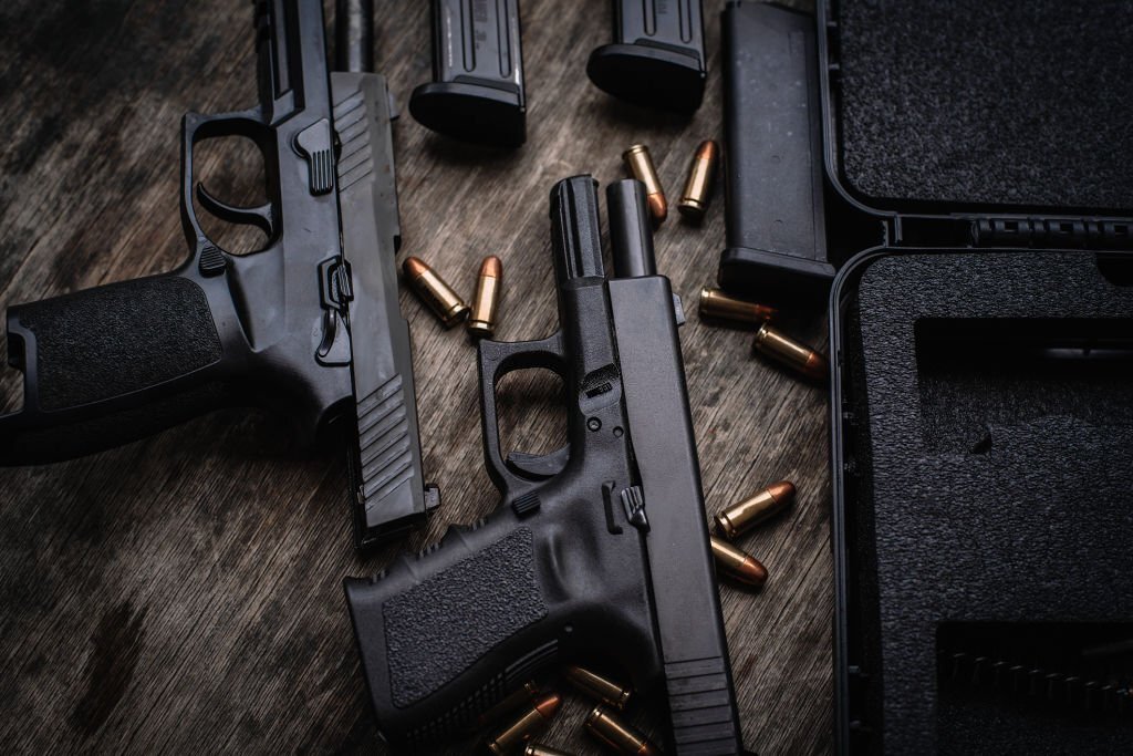 Pistols on a wooden table with bullets