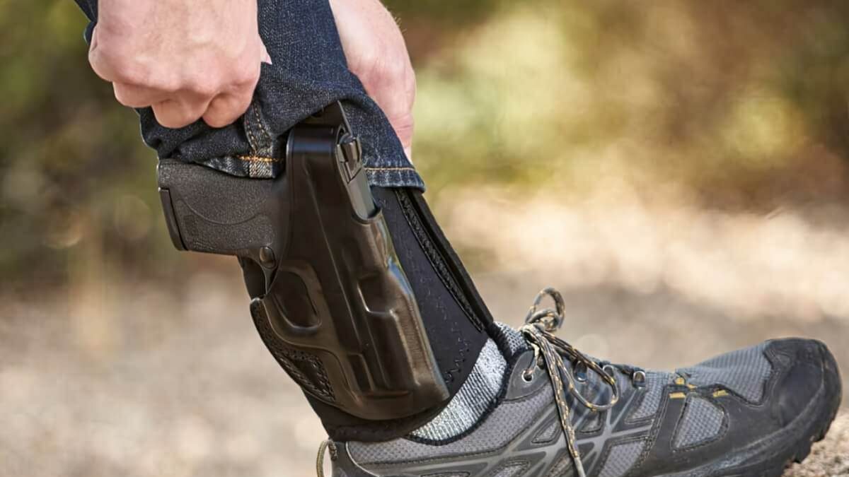A man revealing an ankle holster