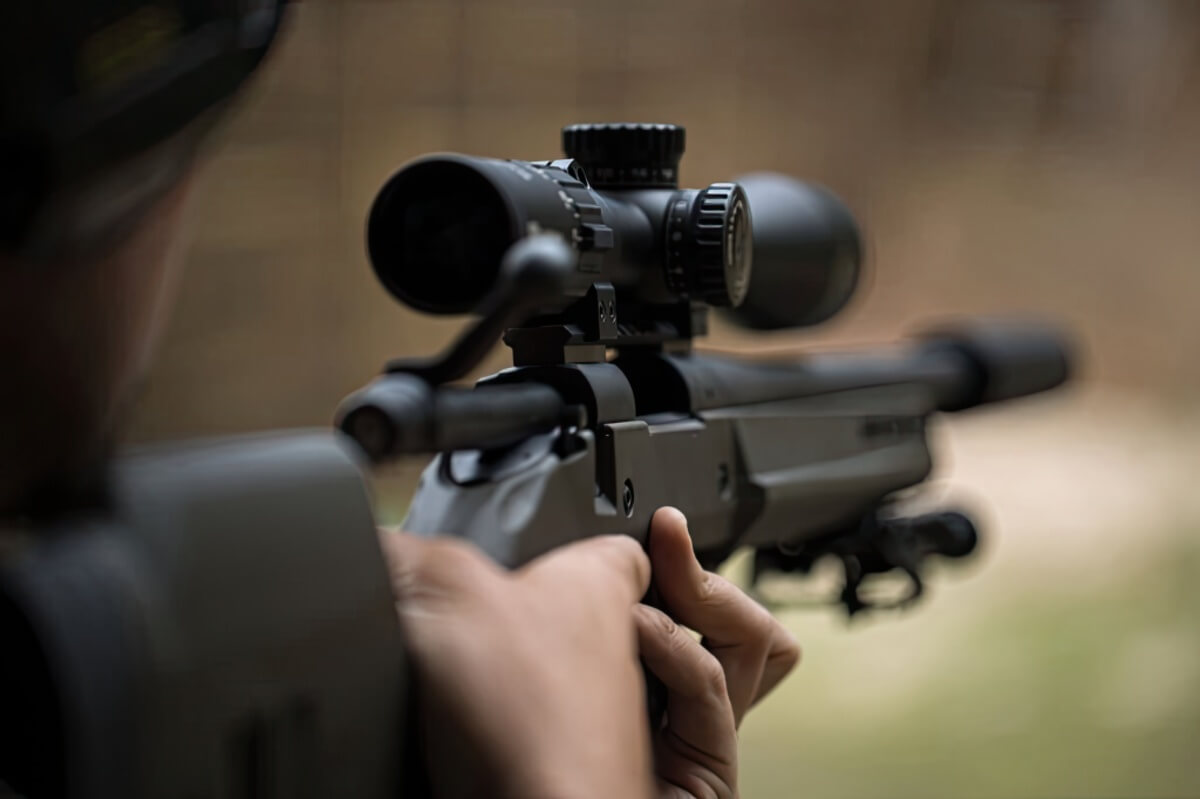 An over-the-shoulder view down a rifle with a scope