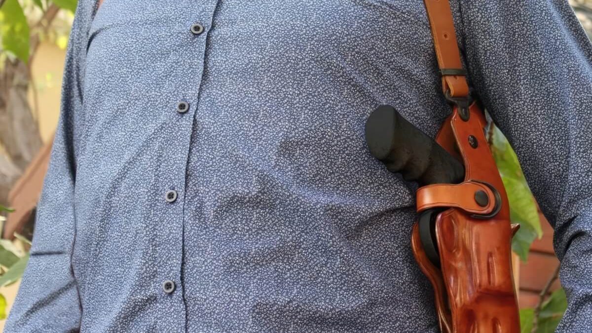 A man wearing a leather shoulder holster