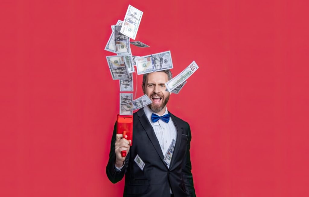 A man in a tuxedo firing cash into the air