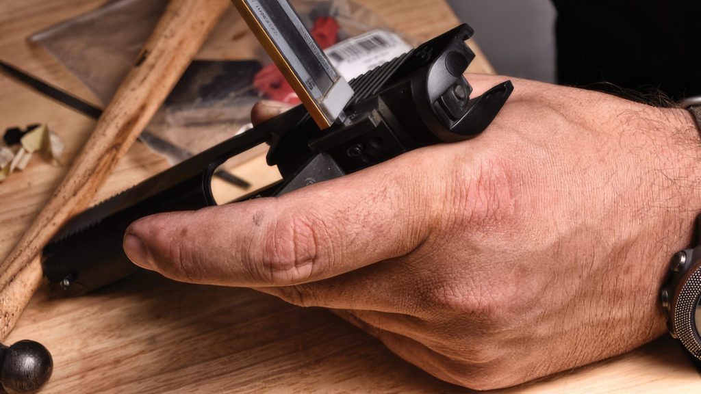 A Gunsmith Repairing A Gun Sight