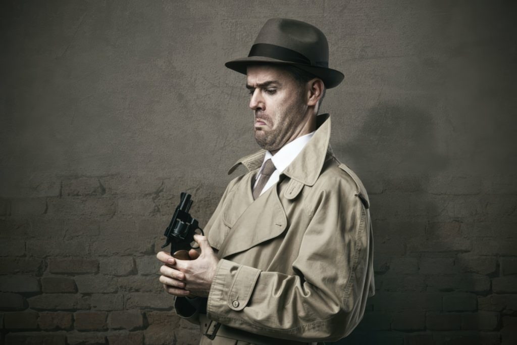 Silly Vintage Detective Pointing A Gun To His Face And Making A Dumb Expression